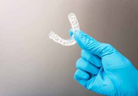 Dentist holding occlusal splint used to address T M J dysfunction