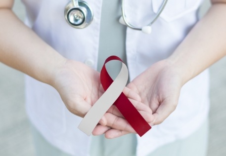 Dentist holding ribbon to raise awareness about oral cancer screenings