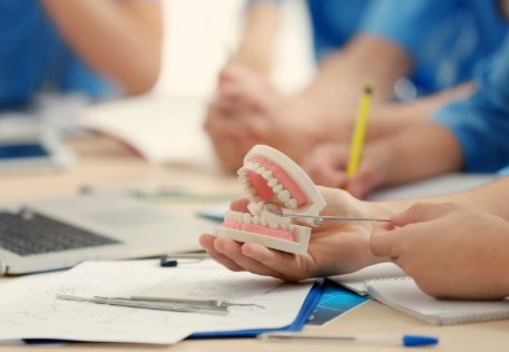 Dentist using smile model to point out the warning signs of oral cancer