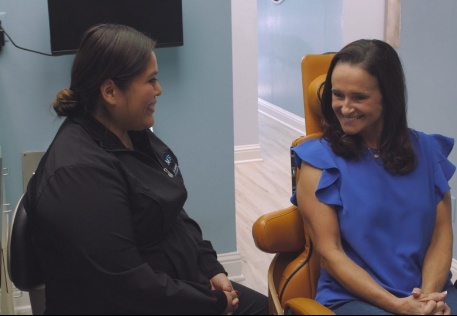 Woman smiling at dental team member during preventive dentistry checkup and teeth cleaning