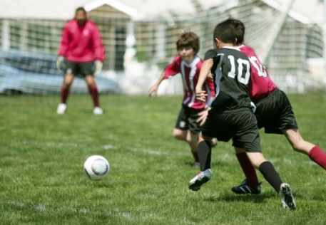 Kids playing soccer wearing athletic mouthguards