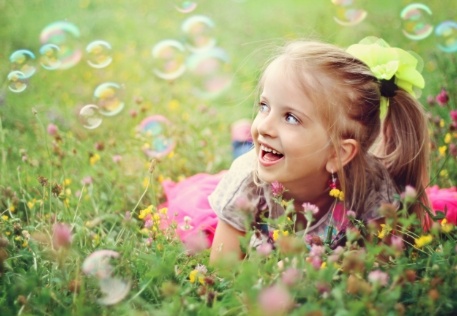 Little girl laughing outdoors after children's dentistry