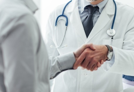 Dentist shaking hands with dental patient