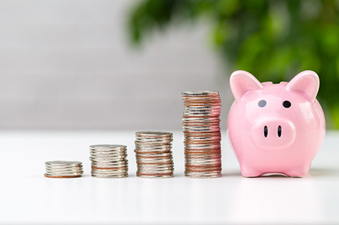 Coins stacked by piggy bank