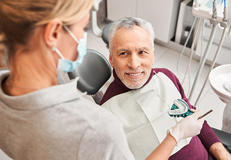 A dentist and their patient discussing dentures