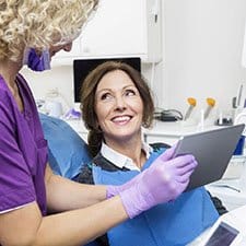 dental hygienist showing a tablet to a patient 