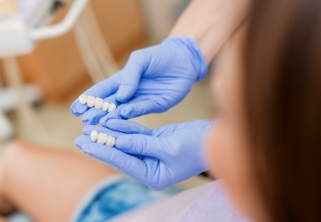 Dentist using model teeth to explain how tooth colored fillings work