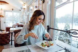 Smiling woman eating lunch at restaurant