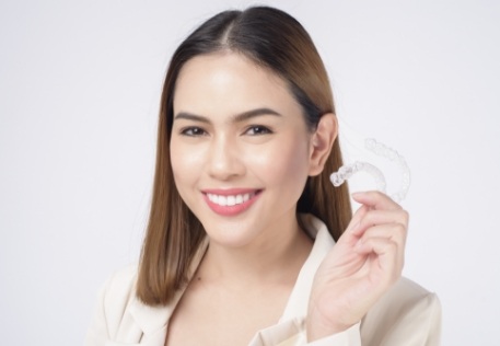 Woman holding an Invisalign tray