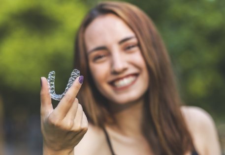 Woman holding an Invisalign tray