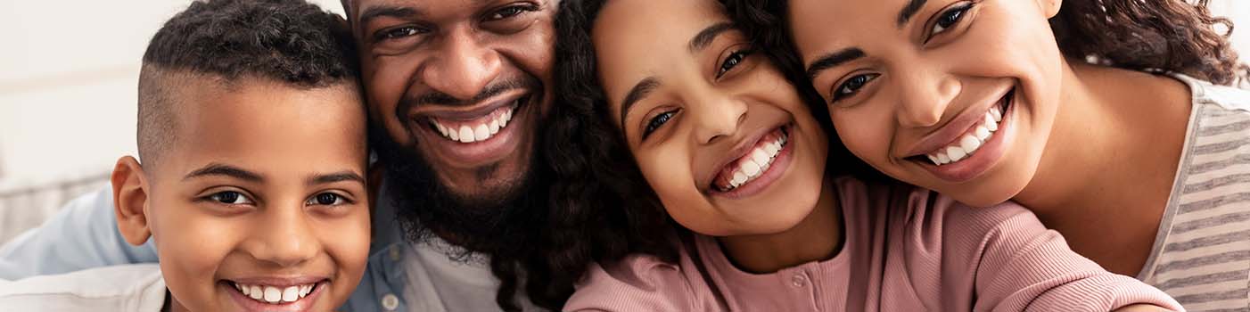 Smiling family of four visiting their Lakewood Texas dentist