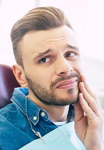 Man holding mouth in pain before emergency dentistry