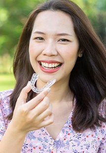 Woman holding invisalign retainer in Lake Highlands