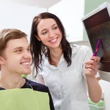 Man and dentist looking at dental x-ray in the office 