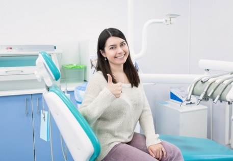 woman giving thumbs up during dental insurance dentist visit