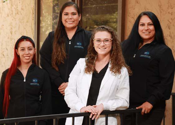 smiling Mariya Barnett with dental team