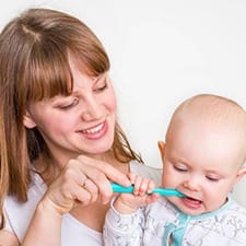 Mom brushing baby’s teeth