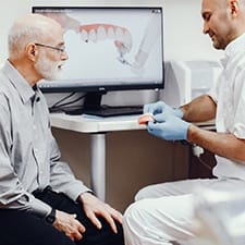 Dentist explaining implant-retained dentures to a patient.