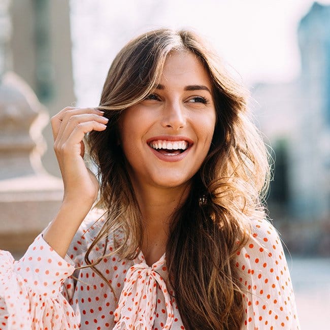 woman smiling bright in polka-dot shirt