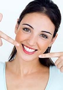 Woman pointing to smile after cosmetic dentistry