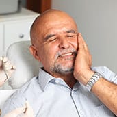 man holding cheek in pain