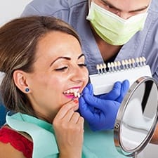 A woman comparing veneers with a dentist