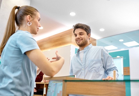 Receptionist explaining cost of teeth whitening in Dallas