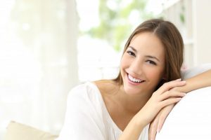 A woman smiling on a couch.