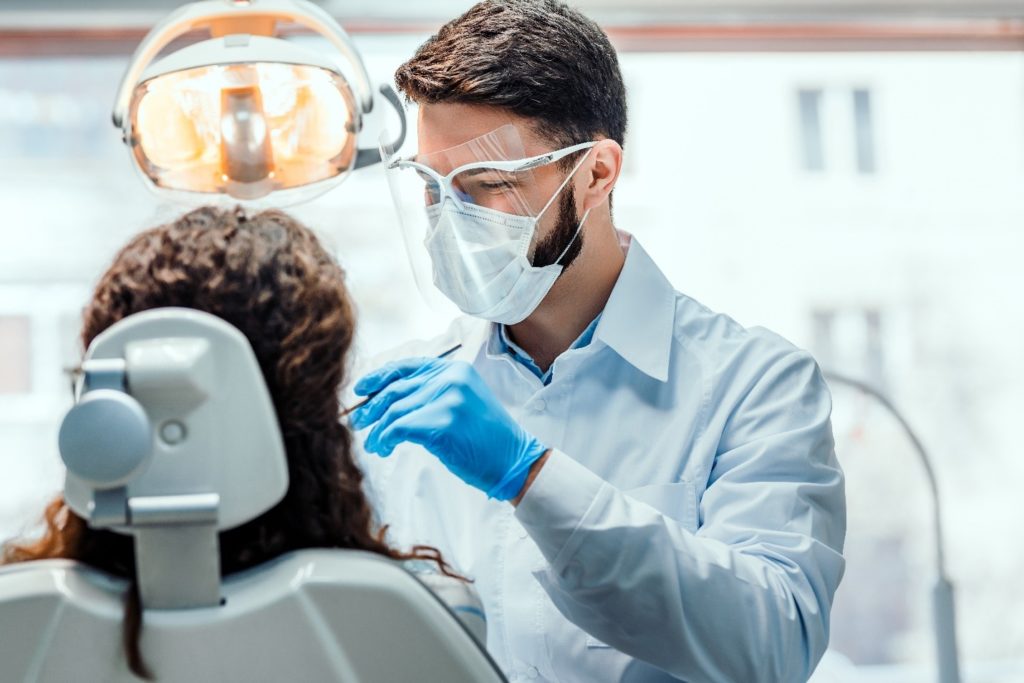 Dentist performing emergency dentistry on a patient.